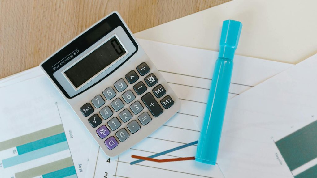 A calculator next to a light blue highlighter.